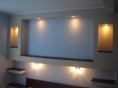 Ściana z dekoracyjnymi wnękami podświetlonymi punktowo i półkami, wykonana w Dobczynie, tworząca nowoczesny wystrój wnętrza.