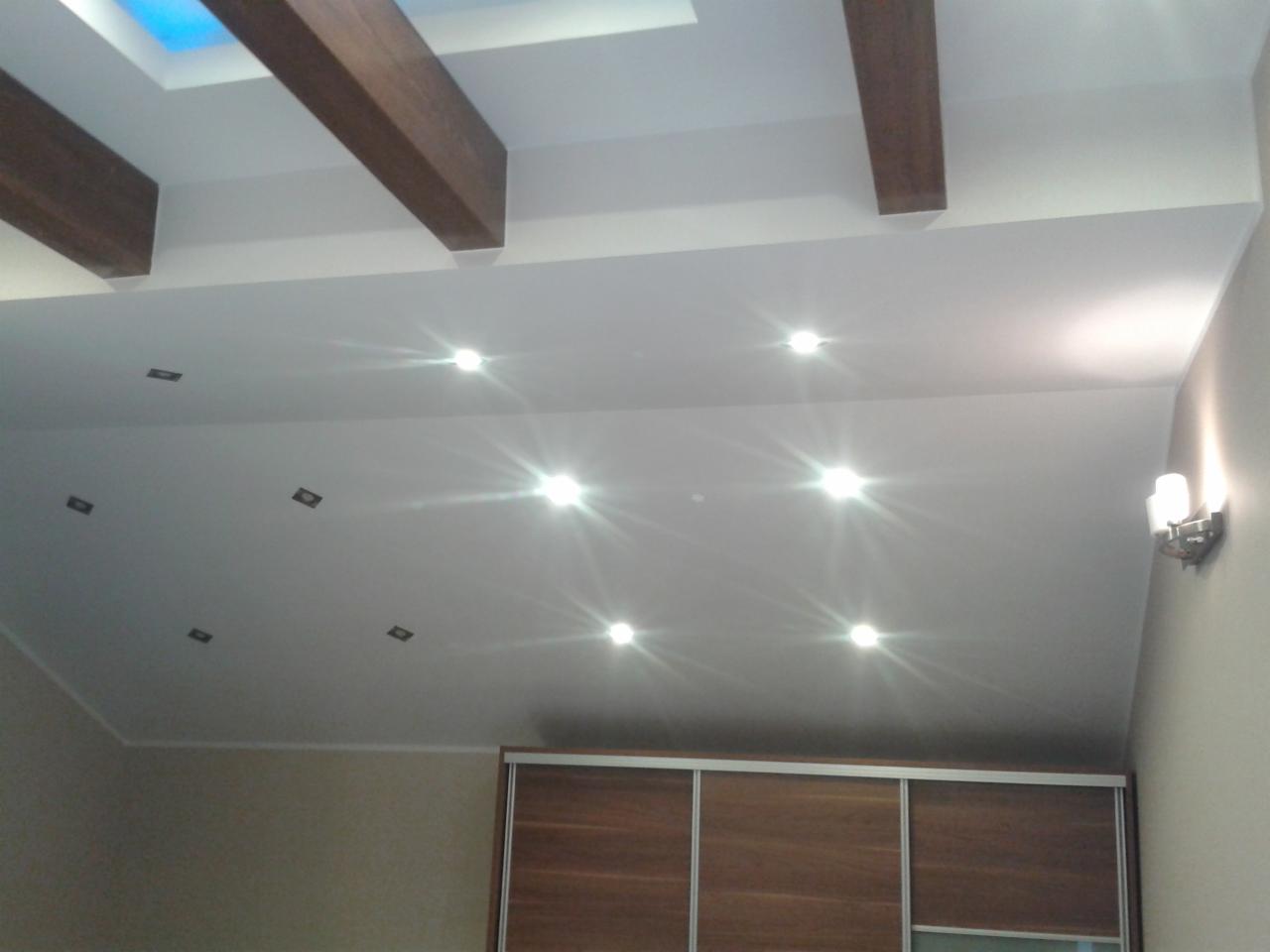 Nowoczesny sufit z punktowym oświetleniem LED i drewnianymi belkami w Czastarach. Energooszczędne rozwiązanie dla domu.