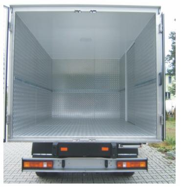 Pusta, czysta i oświetlona przestrzeń ładunkowa furgonetki z aluminiową podłogą i ścianami, widok od tyłu pojazdu.