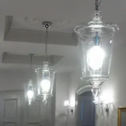 Elegancki korytarz z trzema szklanymi lampami wiszącymi o kształcie lampionów i kryształowymi kinkietami ściennymi, oświetlony ciepłym światłem.