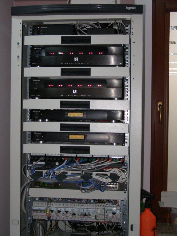 Szafa rack z zamontowanymi urządzeniami sterującymi, przełącznikami i zabezpieczeniami, widoczne liczne przewody i złącza, u góry logo Legrand.