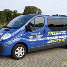 Niebieski bus z napisem 'PRZEWÓZ OSÓB' i numerem telefonu, zaparkowany na zewnątrz, widoczny z boku.