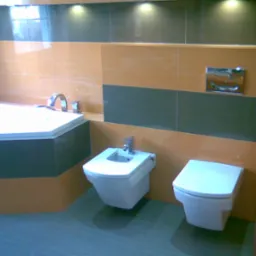 Nowoczesna łazienka z wanną narożną, bidetem i podwieszaną toaletą, wykończona płytkami w odcieniach beżu i szarości, oświetlona punktowymi lampami sufitowymi.