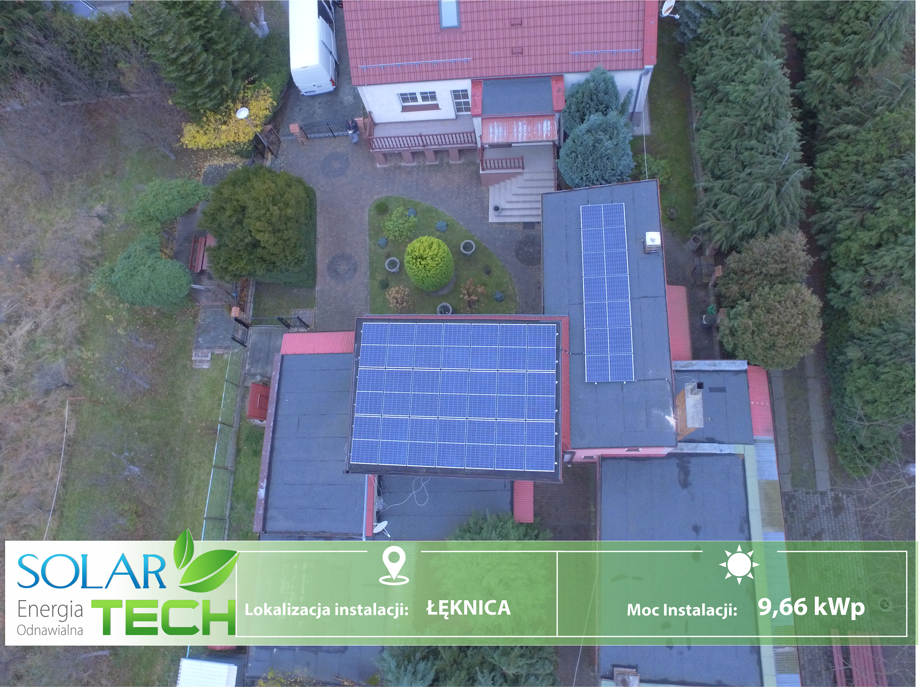 Widok z drona na instalację paneli słonecznych na dachu budynku w Łęknicy, moc instalacji 9,66 kWp, z logo Solar-Tech Energia Odnawialna w rogu.