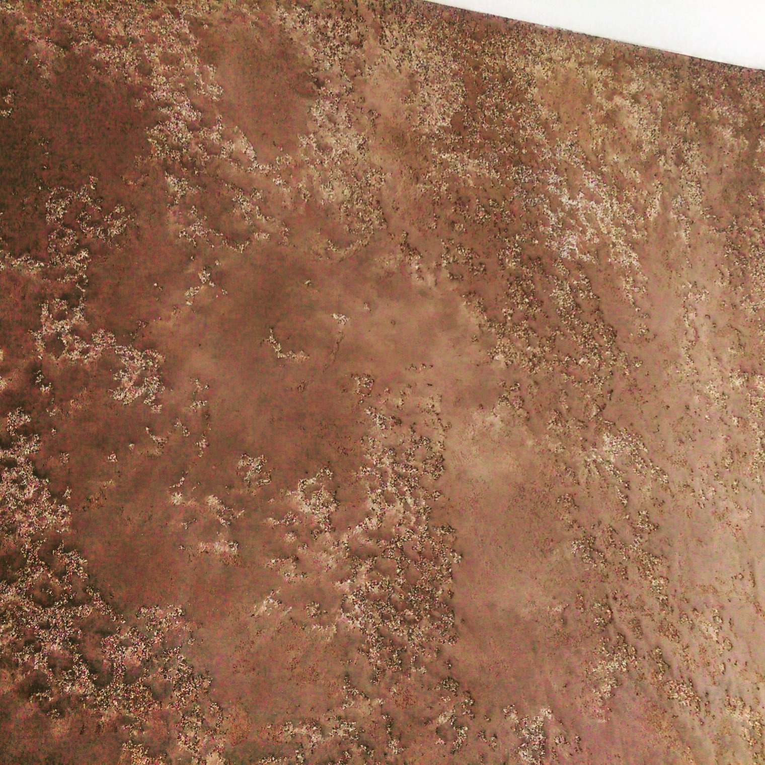 Dekoracyjna ściana w odcieniach brązu z efektem rdzy, widoczna pod kątem. Unikalna faktura i nieregularne plamy tworzą industrialny, surowy wygląd.