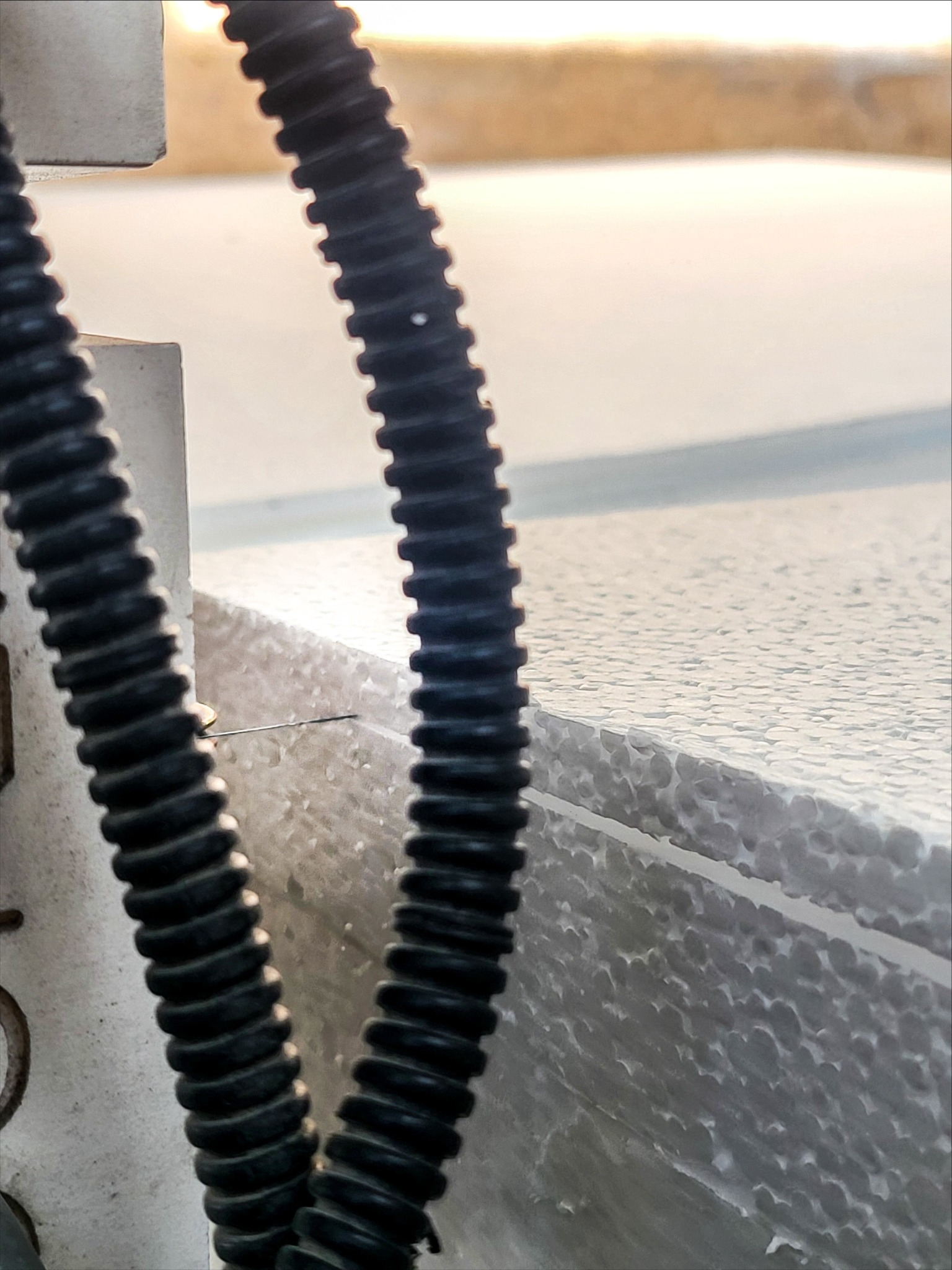 Detale płyty styropianowej z widocznymi przewodami, ukazujące strukturę materiału i precyzję cięcia. Bliskie ujęcie podkreśla jakość i równość krawędzi.