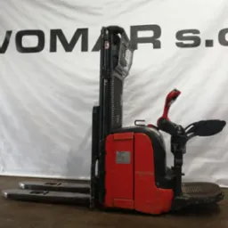 Czerwono-czarny elektryczny wózek widłowy stojący na szarym podłożu, z logo 'WOMAR S.C.' widocznym w tle na białym, pofałdowanym materiale.