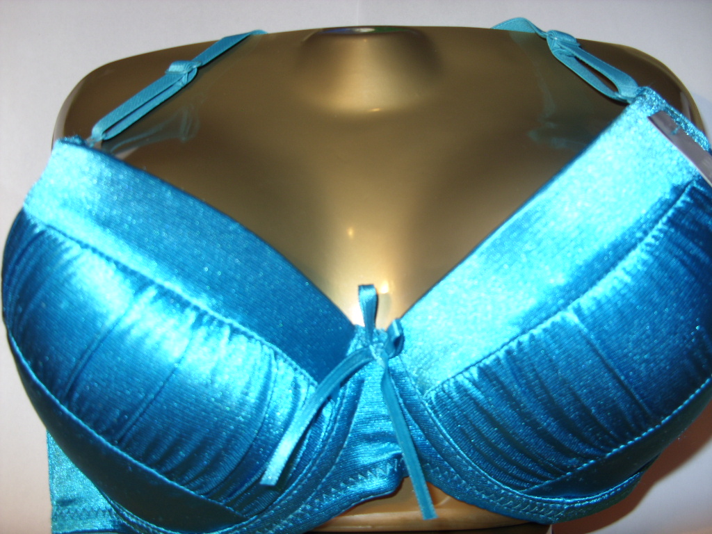 Błękitny satynowy biustonosz na manekinie, z ozdobną kokardką pośrodku, prezentowany w studio.