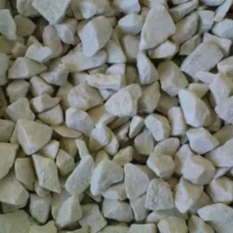 Jasny, drobny żwir wapienny o nieregularnych kształtach, wypełniający całą klatkę, z widoczną teksturą i subtelnymi cieniami.