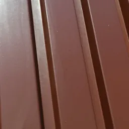 Nowe, brązowe pokrycie dachowe z blachy trapezowej, mocowane na wkręty farmerskie, widoczne z bliska pod kątem.