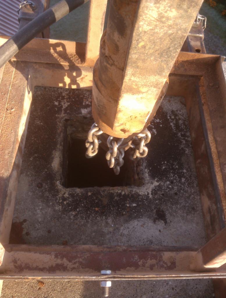 Frezarka kominowa opuszczana na łańcuchach do wnętrza komina o kwadratowym przekroju, widok z góry.