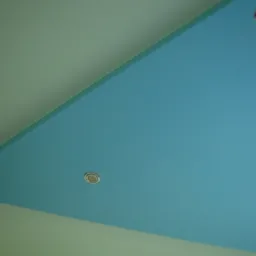 Nietypowy sufit podwieszany w kształcie trójkąta, pomalowany na błękitno, z trzema wpuszczonymi lampkami halogenowymi z metalowymi obwódkami, na tle jasnych ścian.