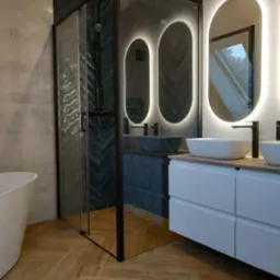 Nowoczesna łazienka z kabiną prysznicową w czarnej ramie, podświetlanymi lustrami o owalnym kształcie, umywalkami nablatowymi na białej szafce i podłogą ułożoną w jodełkę.