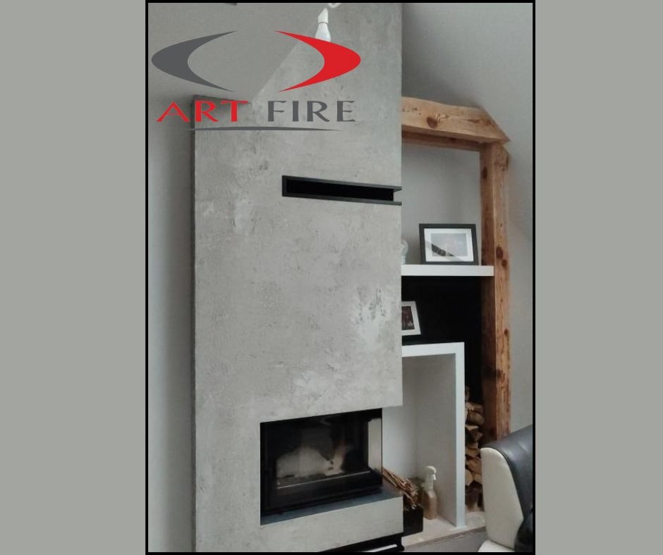 Nowoczesny kominek z szarego betonu architektonicznego, z czarnym wkładem i poziomym wcięciem, obok regał z drewnianą ramą i dekoracjami.