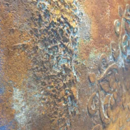 Dekoracyjna, teksturowana ściana w odcieniach brązu i niebieskiego z wytłoczonym wzorem roślinnym. Ujęcie z bliska, ukazujące detale faktury i kolorystyki.