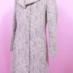 Długi, szary płaszcz z szerokim kołnierzem na manekinie, widoczny czerwony golf pod spodem, na różowym tle.