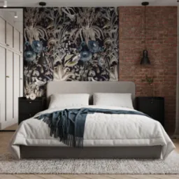 Sypialnia z łóżkiem kontynentalnym, tapetą w kwiaty i ścianą z czerwonej cegły, oświetlona lampami wiszącymi, z szafą w zabudowie z lustrem.