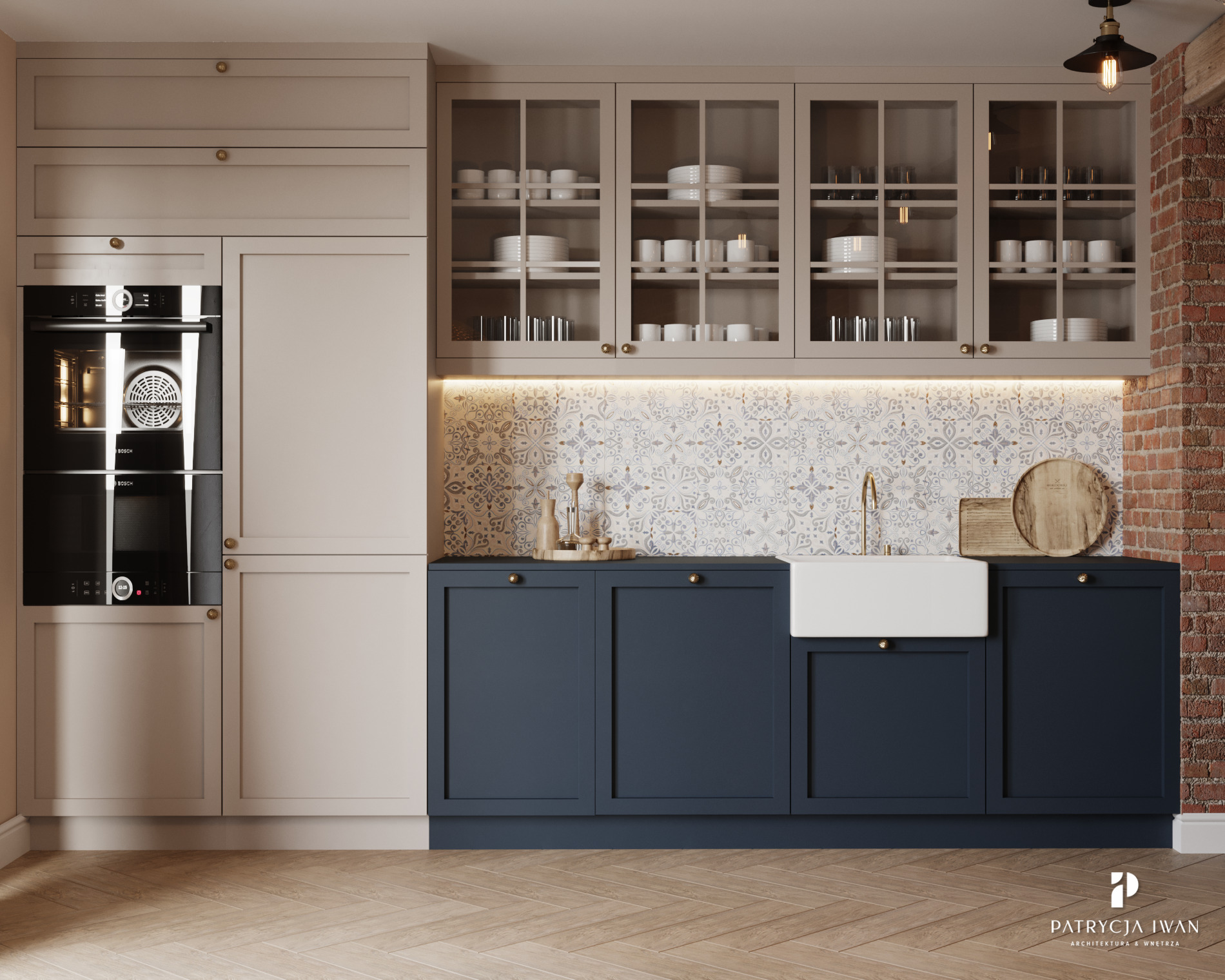 Nowoczesna kuchnia z granatowymi szafkami dolnymi, beżowymi szafkami górnymi z przeszklonymi frontami, białym zlewozmywakiem farmerskim i wzorzystą mozaiką nad blatem, oświetlona wiszącą lampą i...