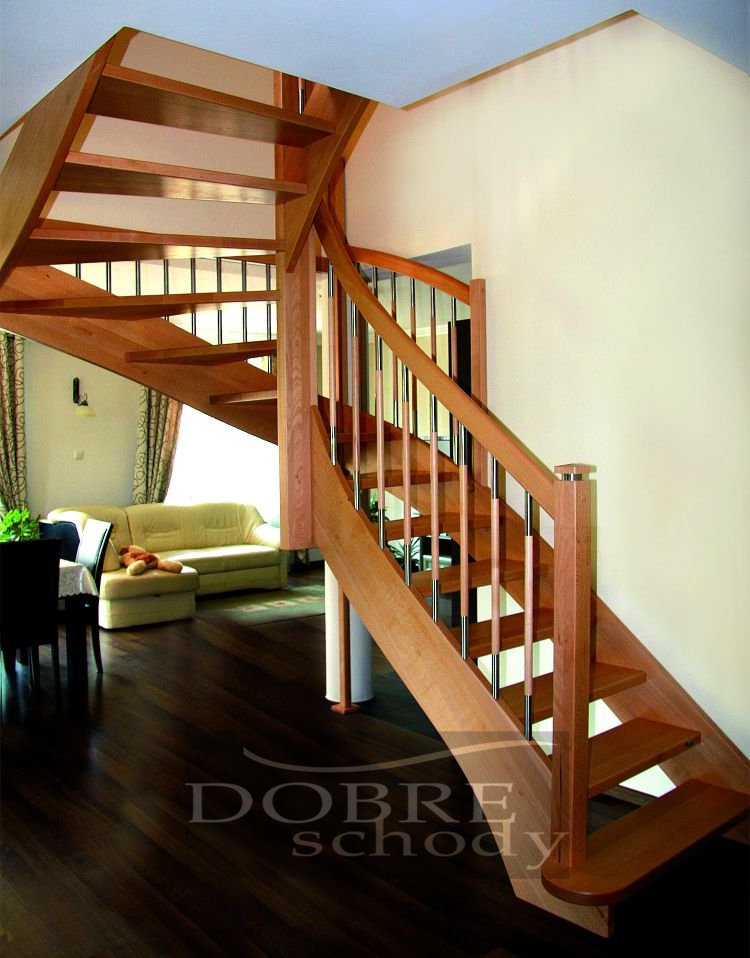 Drewniane schody z metalowymi balustradami, widoczne z dołu, z salonem w tle, gdzie stoi beżowa sofa z pluszowym misiem.