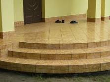 Wyłożone płytkami schody wejściowe do domu, widoczne dwie pary klapek na górnym podeście.