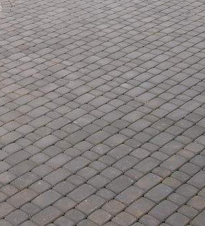 Szara nawierzchnia z kostki ułożonej w jodełkę, widok z góry.