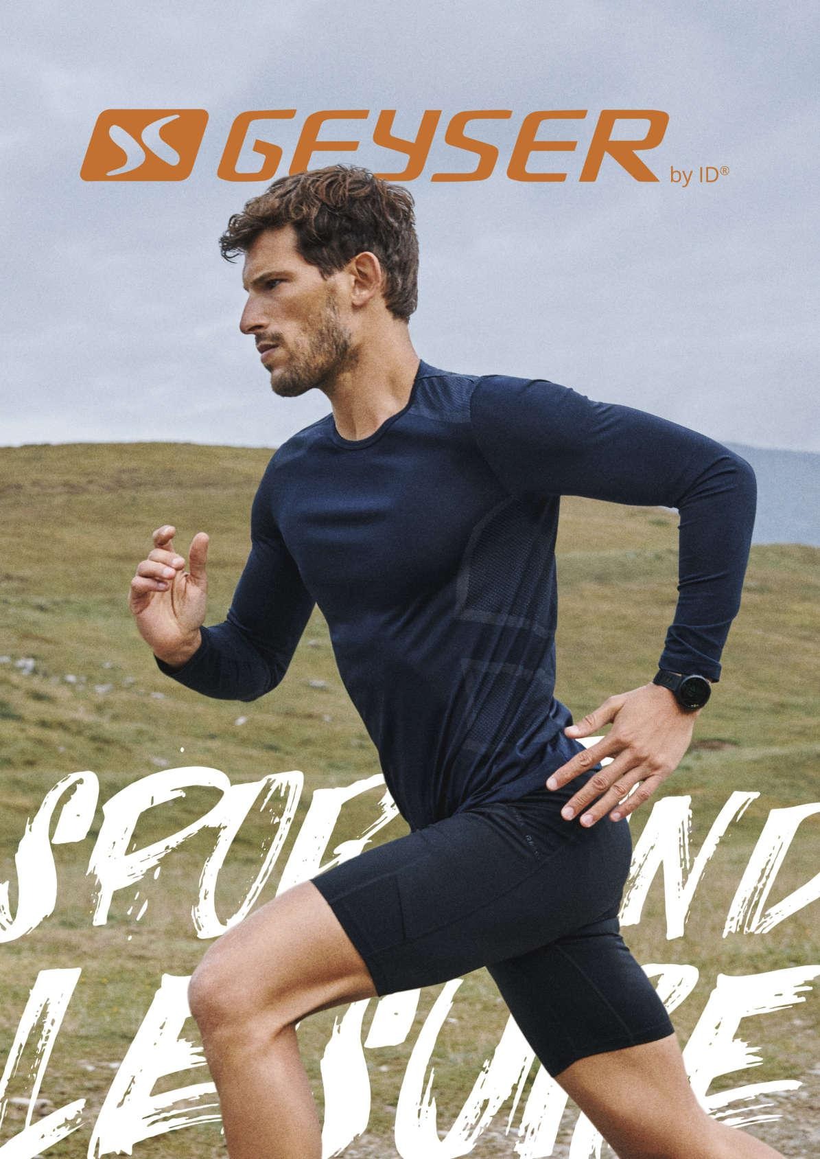 Mężczyzna w granatowej koszulce z długim rękawem i czarnych spodenkach do biegania, biegnący w terenie górskim, z widocznym logo marki Geyser.