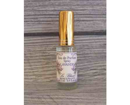 Mała buteleczka perfum lawendowych z złotą zakrętką na tle drewnianej powierzchni.