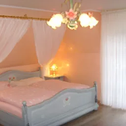 Jasna sypialnia z łóżkiem w stylu vintage, baldachimem z delikatnych firan i kwiecistym żyrandolem.