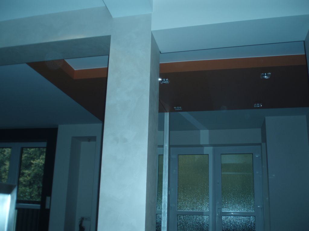 Wykończone wnętrze w Łodzi z dekoracyjną kolumną i podwieszanym sufitem z oświetleniem punktowym.