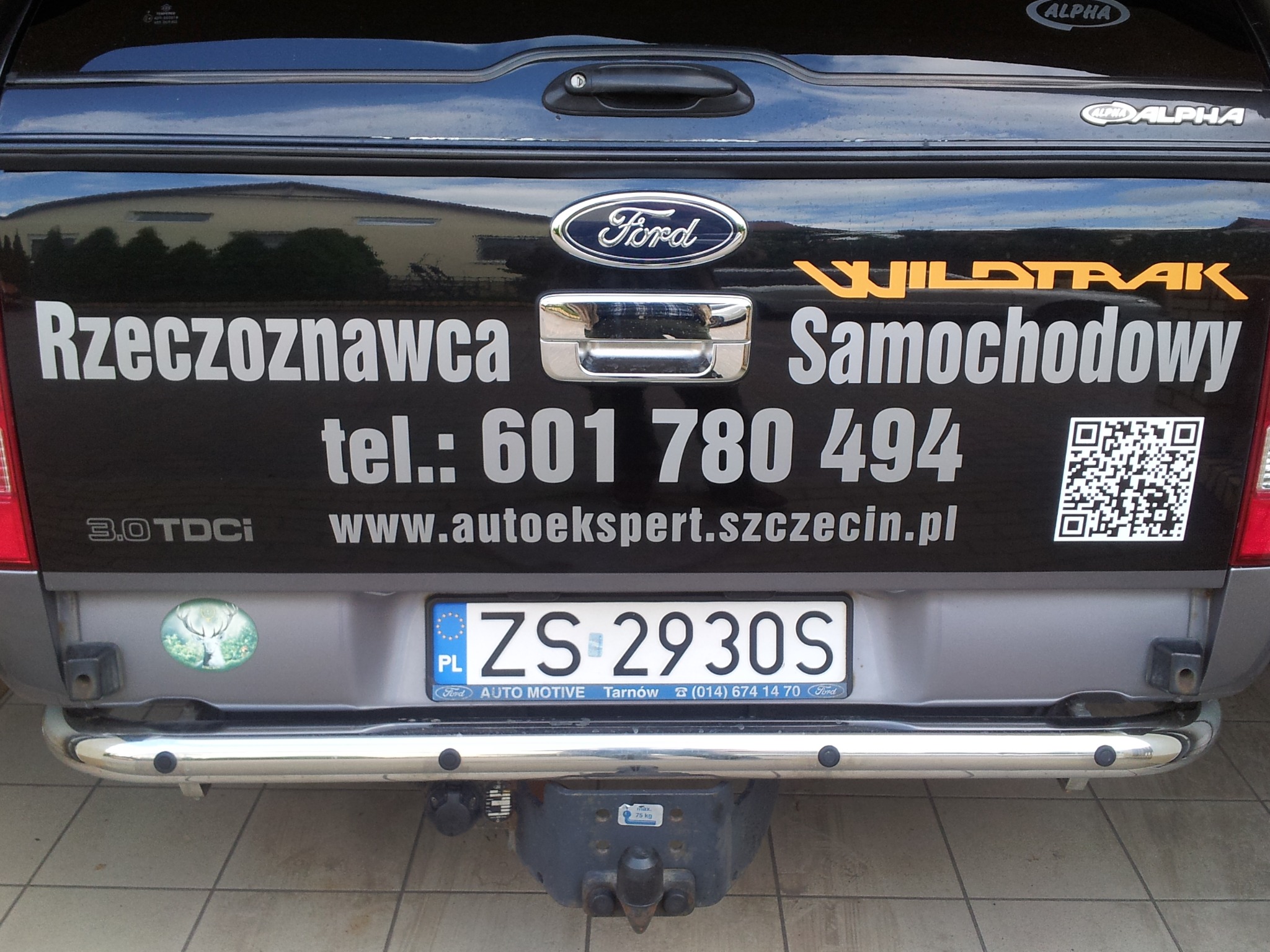 Tył samochodu Ford Wildtrak z naklejką 'Rzeczoznawca Samochodowy', numerem telefonu, adresem strony internetowej autoekspert.szczecin.pl i kodem QR.