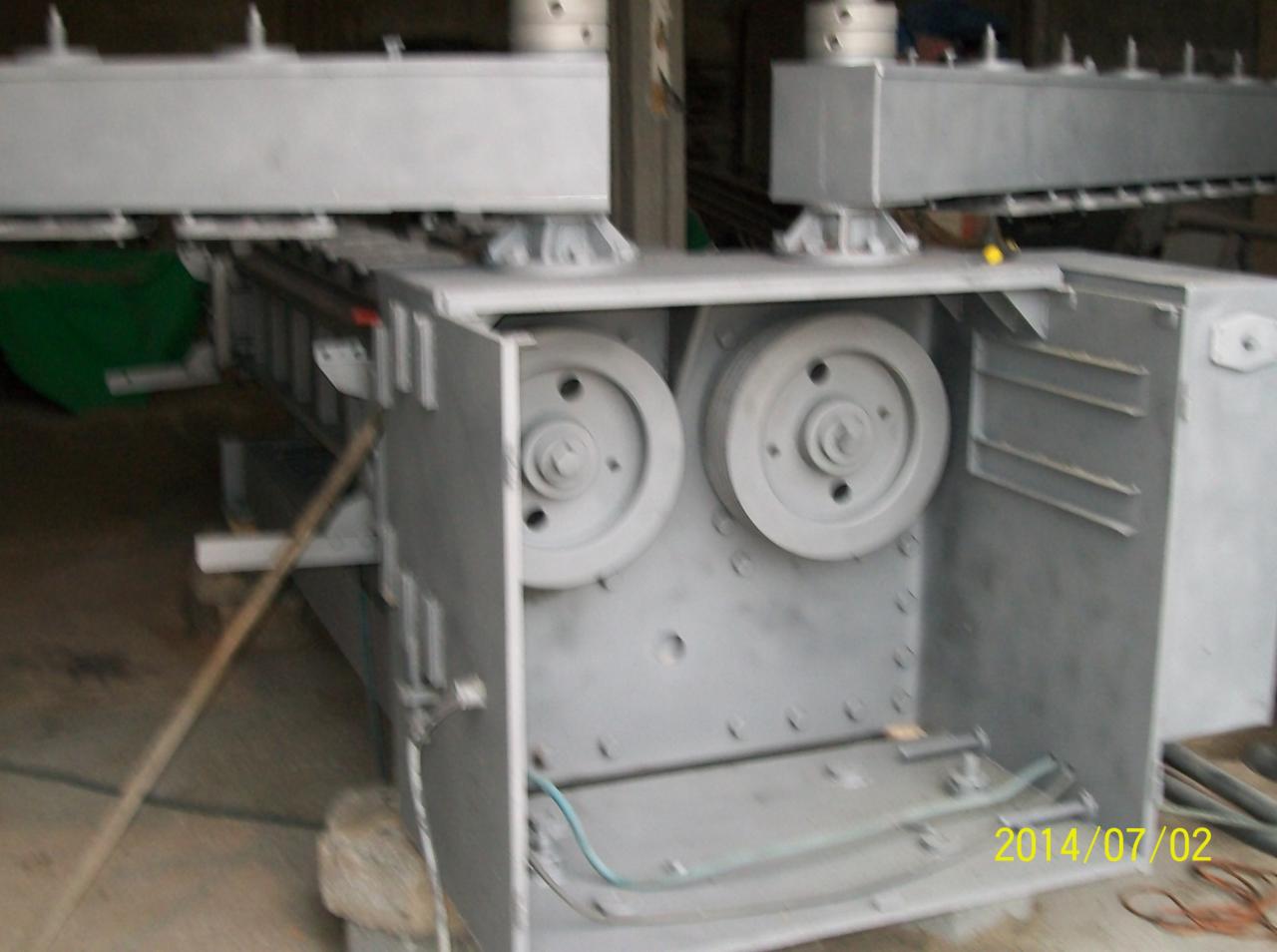 Szara, metalowa konstrukcja z dwoma kołami pasowymi, widoczna data 2014/07/02. Element maszyny w trakcie montażu lub naprawy, detale mocowania i przewody.