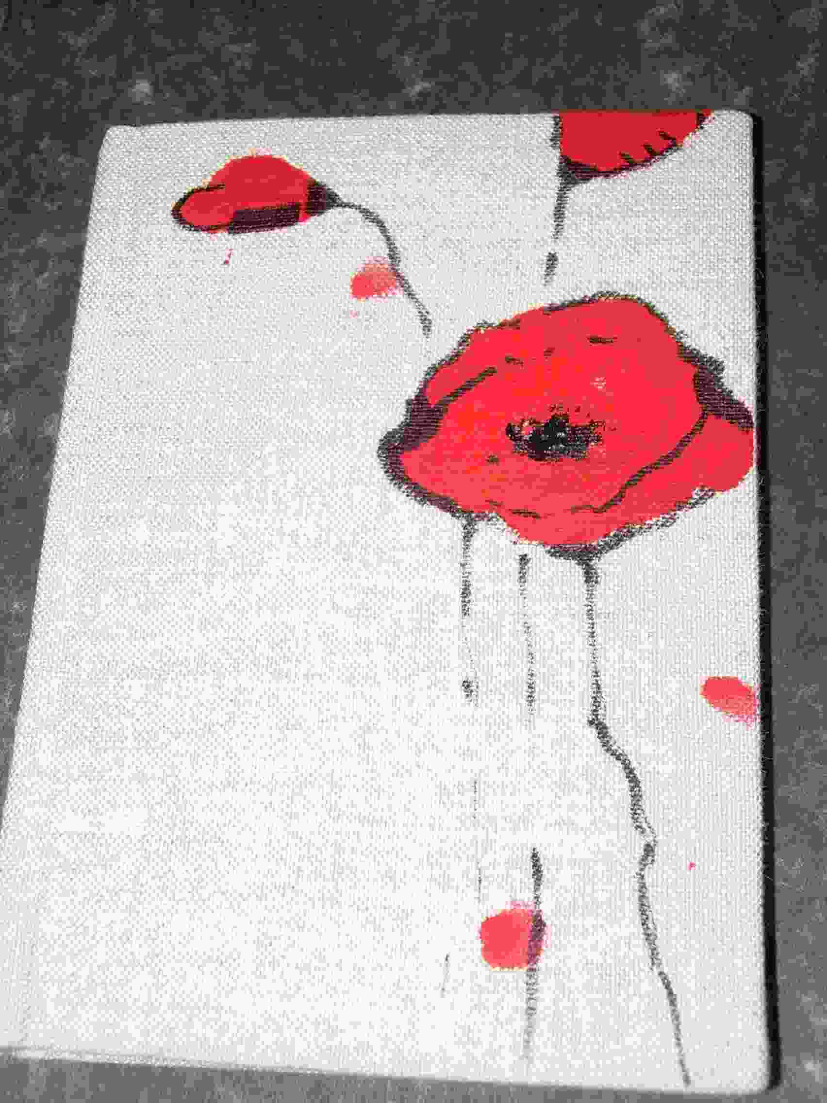 Ręcznie malowany obraz na płótnie przedstawiający czerwone maki na białym tle, z widoczną fakturą płótna.