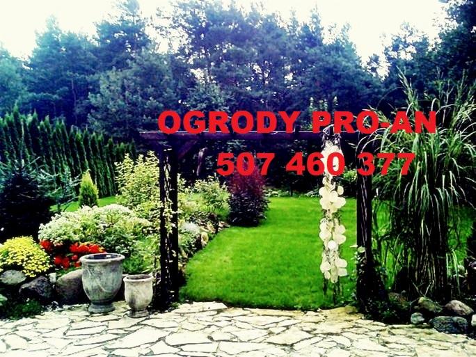 Aranżacja ogrodu z trawnikiem, ścieżką z kamienia i pergolą. Widoczne rośliny ozdobne i drzewa iglaste w tle. Na zdjęciu numer telefonu firmy.