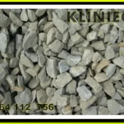 Kliniec w kadrze z numerem telefonu i nazwą firmy, szaro-beżowe kamienie o nieregularnych kształtach.