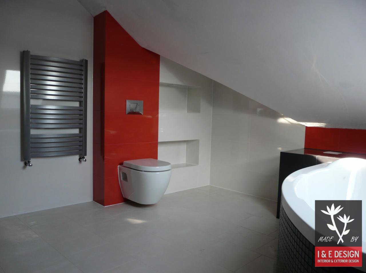 Nowoczesna łazienka w Radomsku po remoncie: białe płytki, czerwony akcent, podwieszana toaleta i grzejnik drabinkowy w pomieszczeniu ze skosami na poddaszu.