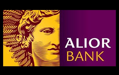 Grafika przedstawia logo Alior Banku, po lewej stronie stylizowana głowa postaci mitologicznej w odcieniach żółci i brązu, po prawej nazwa banku na fioletowym tle.