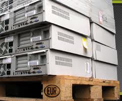 Stos starych serwerów komputerowych, ułożonych na drewnianej palecie EUR, przygotowanych do recyklingu lub utylizacji.