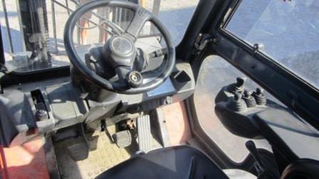 Wnętrze kabiny wózka widłowego Toyota 7FGF 15 z 2006 roku, widoczna kierownica, pedały i dźwignie sterujące, perspektywa z miejsca operatora.