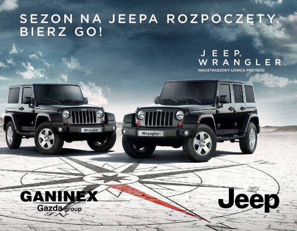 Dwa czarne Jeepy Wrangler prezentowane na tle pustynnego krajobrazu z naniesioną grafiką kompasu i hasłem reklamowym 'Sezon na Jeepa rozpoczęty. Bierz go!'