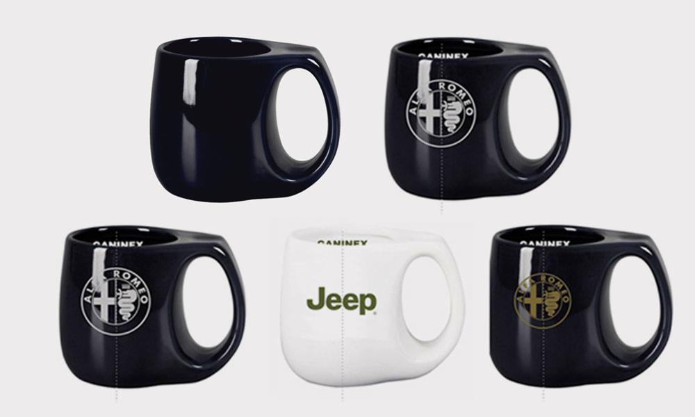 Kolekcja kubków z logo: czarny kubek bez nadruku, kubki z logo Alfa Romeo w kolorze białym i złotym oraz biały kubek z zielonym logo Jeep.