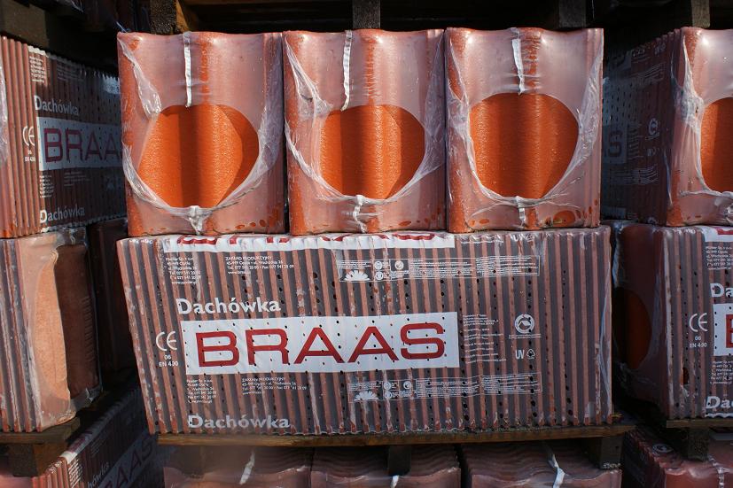Paleta czerwonych dachówek betonowych marki Braas, zapakowanych w folię, ułożonych na drewnianej palecie.