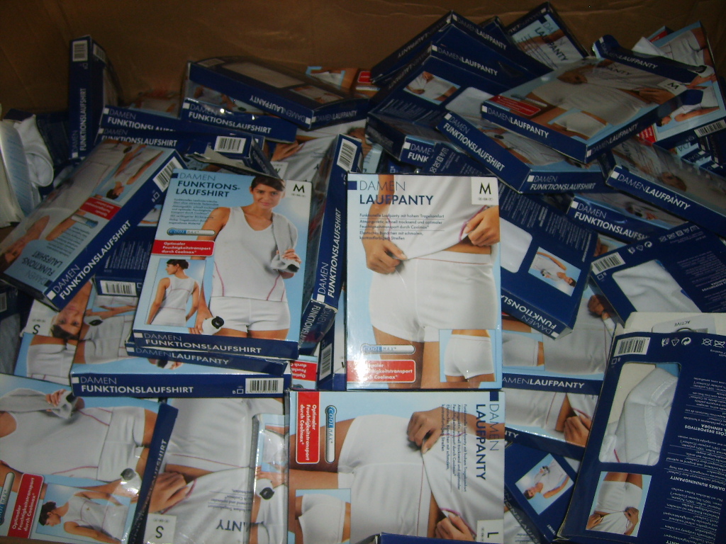 Stos pudełek z damskimi koszulkami i majtkami sportowymi COOLMAX, widok z góry na otwarte kartonowe pudło wypełnione produktami.