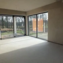 Nowa wylewka w surowym wnętrzu z dużymi oknami przesuwnymi i widokiem na las.