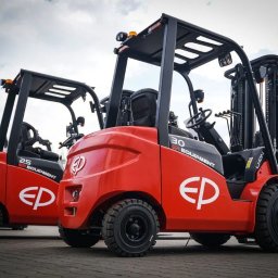 SETMIL Sp. z o.o. - Dwa czerwone wózki widłowe EP Equipment, model 30 i 25, stoją obok siebie. Widoczne detale opon, kabiny i masztów. Tło: pochmurne niebo.