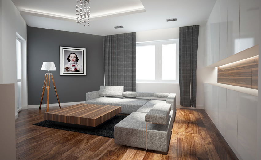 Nowoczesny salon z szarą ścianą, drewnianą podłogą i narożną sofą z jasnej tkaniny. Na ścianie obraz w czarnej ramie i lampa na drewnianym trójnogu. Centralnie stolik kawowy z ciemnego drewna...