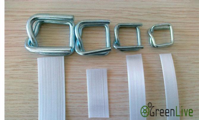 Różne rozmiary metalowych zapinek drucianych oraz fragmenty taśm PP, ułożone na drewnianej powierzchni.