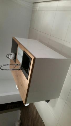 Fragment blatu kuchennego z wbudowanym zlewem i baterią, wykończony drewnem i białym laminatem, widok z góry pod kątem.