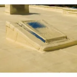 Poddasze z oknem dachowym pokryte jednolitą warstwą jasnej pianki izolacyjnej, widoczne elementy konstrukcyjne i komin również zabezpieczone pianką.