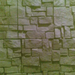 Tekstura ściany z płytek elewacyjnych imitujących kamień naturalny w odcieniach szarości i beżu, z widocznymi spoinami.