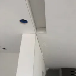 Montaż płyt karton-gips na suficie podwieszanym z widocznymi otworami na oświetlenie punktowe, wykończone listwy przypodłogowe sufitowe.